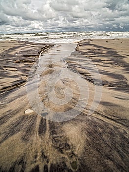 Tidal watercourse and marks on the beach