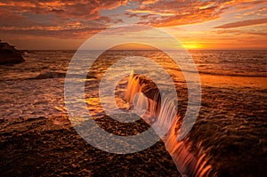 Tidal waterfalls coloured by summer sunrise scenic landscape Australia