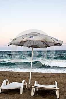 Tidal waves, sandy beach, sun loungers and sun umbrella