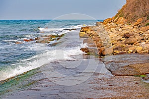 The tide submerging the narrow coastal walkway at Peveril Point Swanage England