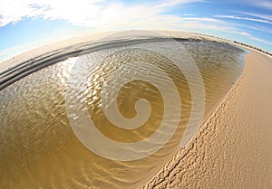 Tidepool of water on beach.
