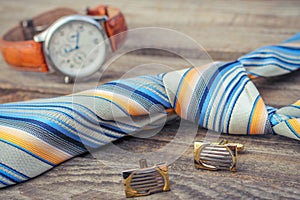 Tie, cufflinks and watches on the old wood background