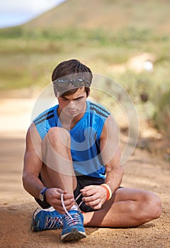 Tie, runner or man with shoe lace for fitness training, walking exercise or workout on path or sand. Running, wellness
