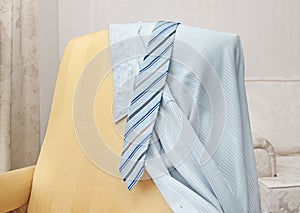 tie and shirt hanging on a chair