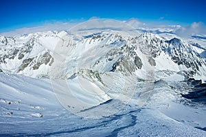 Tied climbers climbing mountain with snow field tied with a rope with ice axes and helmets