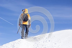 Tied climbers climbing mountain with snow field tied with a rope with ice axes and helmets