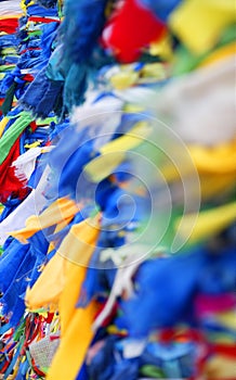 Tied colored ribbons on the wooden shaman totems, sacred poles at Burhan Cape, Baikal Lake, Russian Federation