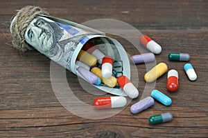 Tied With Rope Hundred Dollar Bill With Many Colorful Drugs photo