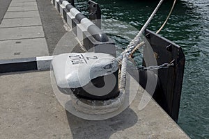 Tied rope on the knot around the mooring bollard. Nautical theme background