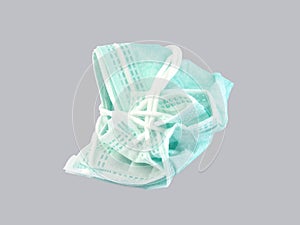 tied up used surgical face mask isolated on gray background
