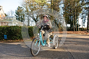 Tienen, Flanders, Belgium - Happy woman with the Down Syndrome driving a tricycle photo