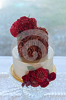 2 tier wedding cake decorated with gold and red rosette ruffles