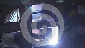 Tig welding in dark factory, worker technician with mask. Slow motion