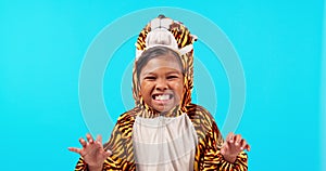 Tiger costume, roar and face of girl in studio with halloween onesie for fun, playful and playing. Childhood, blue