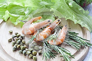 Tiger Prawn Shrimps with green lettuce, capers and rosemary.