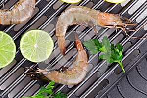 Tiger shrimps on black pan.