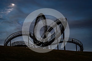 Tiger and Turtle, walkable roller coaster sculpture with illuminated stair railing at night, art installation and landmark in