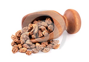 Tigernuts isolated on white background. Chufa nuts or tiger nuts in wooden scoop photo