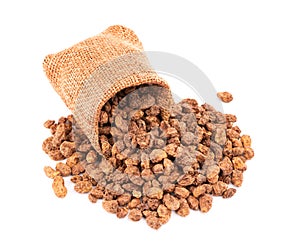Tigernuts in small burlap sack, isolated on white background. Chufa nuts or tiger nuts photo