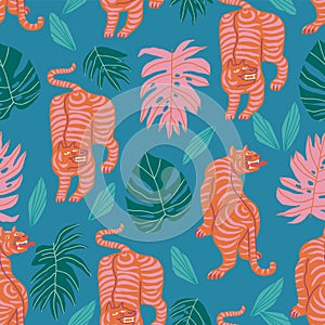 Tigers with tropical jungle leaves on the green blue background seamless pattern.