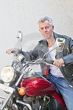 Tight lipped motorbiker on a red cruiser