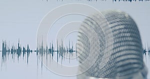 Tight pattern of professional vocal microphone in front of waveform digital audio recording screen