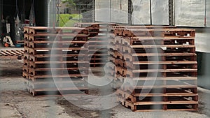 tight shot, piles of wood palettes skids, pavement, outdoor canopy tent-