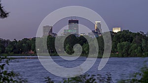 A tight twilight shot of the skyline above the treeline in South Minneapolis` Lake of the Isles on a Windy Summer Evening