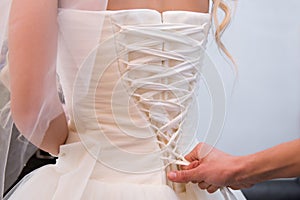 Tighten wedding dress on bride