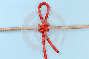 Tightened rope Slipped constrictor knot on a blue background