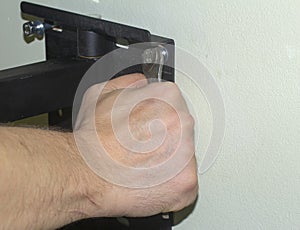 Tightening the bolt with a wrench. Attaching of the Mount to the Wall