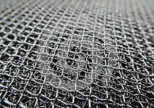 Tightly woven metal mesh with a uniform grid pattern, composed of