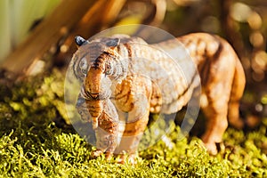 Tigress with cub in teeth. Tiger toy figurine in situation.