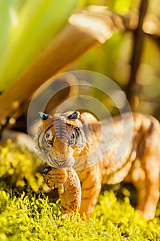 Tigress with cub in teeth. Tiger toy figurine in situation.