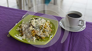 TIGRILLO is a typical dish consisting of ground green banana with cheese served in a green plate on a purple table accompanied photo