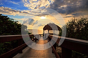 Tiki hut Boardwalk leads down to the white sand of Barefoot Beach in Bonita Springs