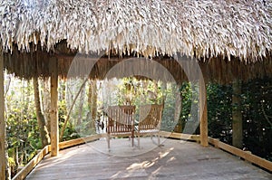 Tiki hut and chairs in swamp