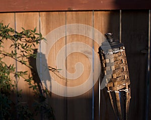 Tiki torch shadow on the fence