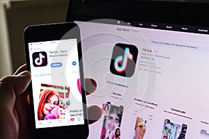 TikTok mobile video-sharing app company logo on phone screen with internet homepage in background