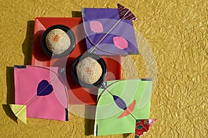Til ka Laddoo made of Sesame seeds and jaggery or sugar, also known as Til baati. Sankranti food celebration with kites. Yellow