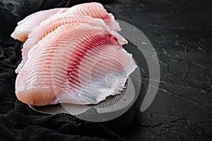 Tilapia fish skinless meat, on black background