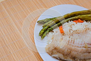 Tilapia sea fish with rice and green asparagus on a white thai. Healthy eating