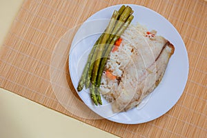 Tilapia sea fish with rice and green asparagus on a white thai. Healthy eating