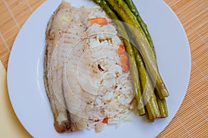 Tilapia sea fish with rice and green asparagus on a white thai. Healthy eating