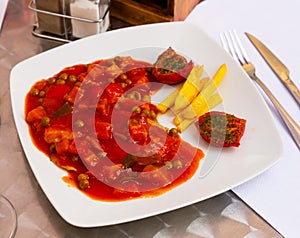 Tilapia with vegetable stew, french fries and sun-dried tomato