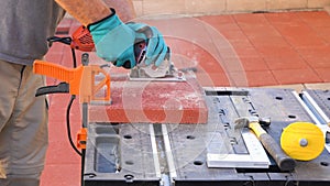 Worker cutting paving tiles for laying on the terrace using circular saw electric