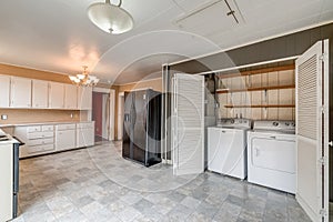 Tile floor black refrigerator laundry room kitchen real estate washer dryer white cabinets