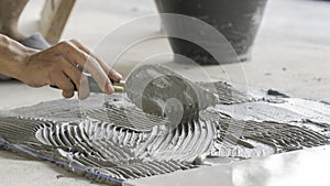 The tile glues the tile to the floor with a glue applied by a notched trowel