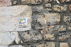 Tile illustrated with a hunter and his dog, with inscription, Here lives a hunter