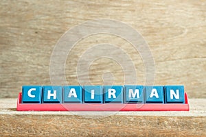 Tile letter on rack in word chairman on wood background